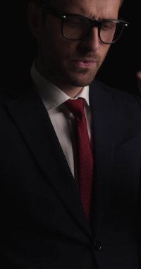 Gözlüğünü çıkarıp kameraya gülümseyen yakışıklı bir iş adamına yaklaş.