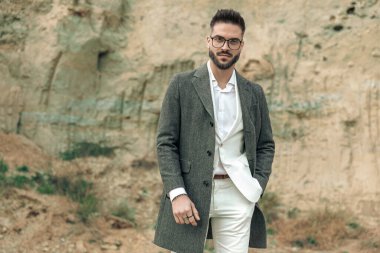 Doğada poz verirken el ele tutuşan gözlüklü yakışıklı bir gencin portresi.