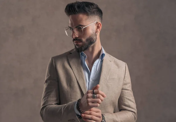 Portrait Bearded Young Man Eyeglasses Looking Side Fixing Sleeve Brown — Stock Photo, Image