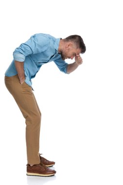 Tıraş olmamış seksi bir adam. Alnından tırnağına kadar bakıyor. Stüdyoda beyaz arka planda küçük bir şey görmeye çalışıyor.