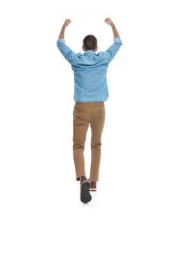 Mavi kot gömlekli, yumruklarını havaya kaldırmış ve beyaz arka planda tek başına yürüyen zeki, sıradan bir adamın bakışının ardında.