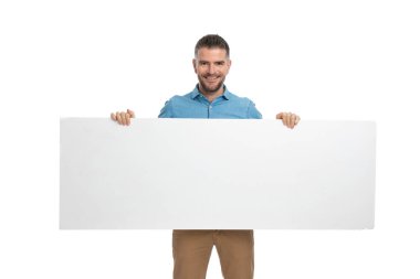 Beyaz saçlı, sakallı, beyaz ilan panosunda reklamını yapan ve gülümseyen mutlu adam. 