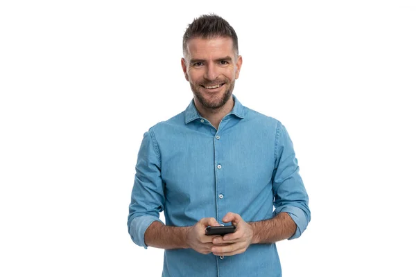 Feliz Homem Sem Barba Camisa Jeans Sorrindo Enquanto Segurando Móvel — Fotografia de Stock