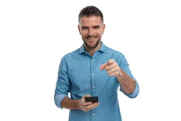 Szczęśliwy Brodaty Mężczyzna Telefonem Ręku Wskazując Palcem Uśmiechając Się Białym — Zdjęcie stockowe