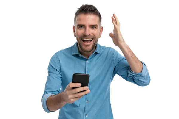 Portrét Ležérní Muž Vousy Držící Telefon Držící Ruku Vzduchu Zatímco — Stock fotografie