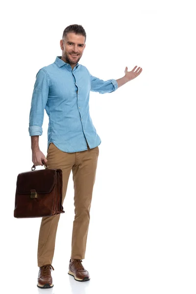 全身写真のハンサムな男にスーツケースがプレゼントされスタジオで白い背景で笑顔 — ストック写真
