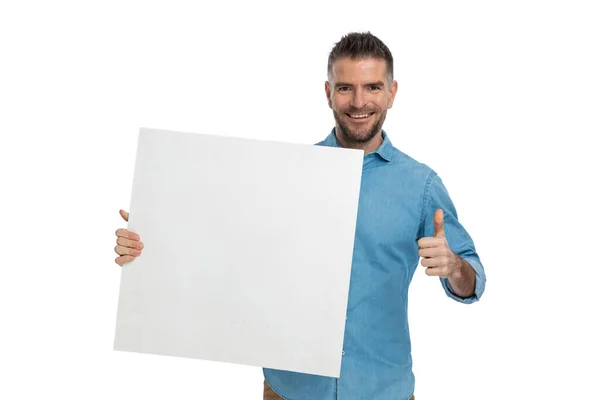 Portret Uśmiechniętego Atrakcyjnego Młodego Faceta Trzymającego Deskę Robiącego Kciuki Białym — Zdjęcie stockowe