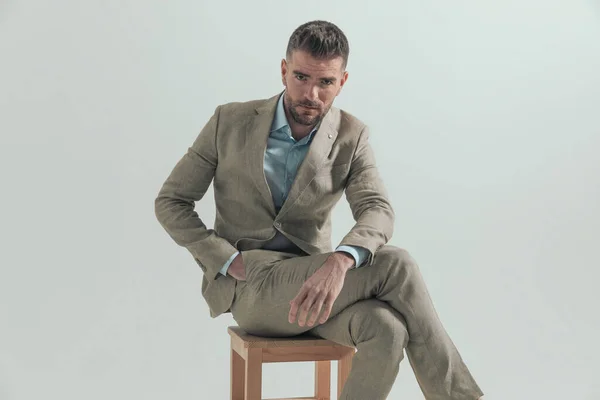 Δροσερό Και Αξύριστος Καθισμένος Επιχειρηματίας Κοστούμι Ανοιχτό Γιακά Πουκάμισο Κρατώντας — Φωτογραφία Αρχείου