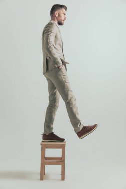 Takım elbiseli orta yaşlı bir işadamı eski hayatını geride bırakıp, arkasında kötü şeyler bırakarak gri arka planda geriye bakmadan yoluna devam ediyor.