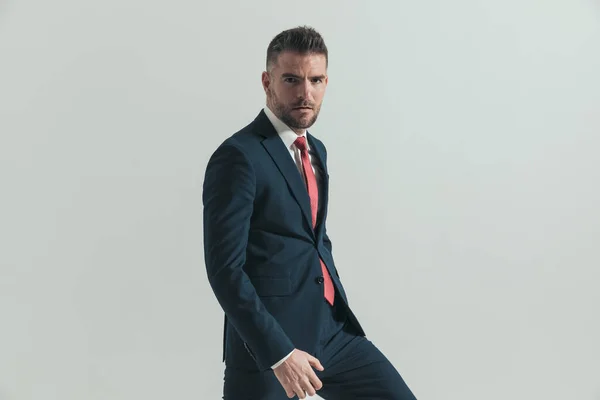 40代のクールなビジネスマンがエレガントなスーツを着て自信を持って灰色の背景にポーズをとって — ストック写真