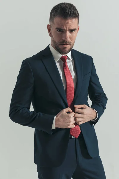 Confident Unshaved Man Beard Buttoning Elegant Suit Posing Front Grey — Stock Photo, Image