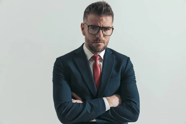 Serious Businessman Eyeglasses Crossing Arms Frowning Front Grey Background Studio — Stock Photo, Image