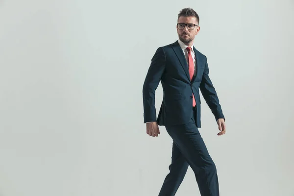 Widok Boku Sexy Biznesmen Okulary Patrząc Daleko Chodzenie Przed Szarym — Zdjęcie stockowe
