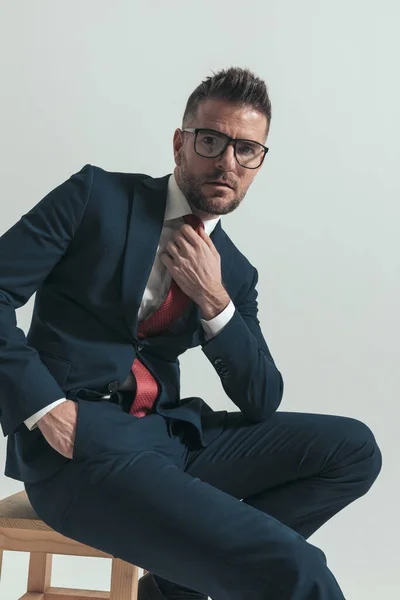 Elegant Bearded Businessman Glasses Arranging Red Tie Posing While Sitting — Stock Photo, Image