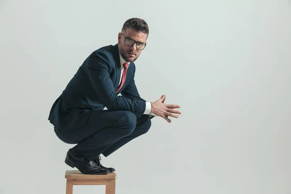 Zijaanzicht Van Aantrekkelijke Man Veertig Hurkend Houten Stoel Palmen Aanraken — Stockfoto