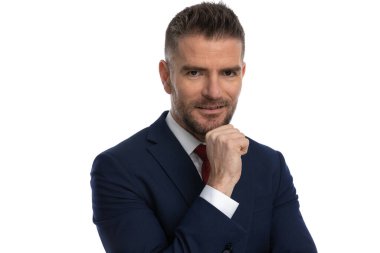 Düşünceli orta yaşlı iş adamının portresi. El ele tutuşup stüdyoda beyaz bir arkaplan önünde düşünüyor.