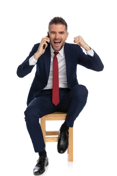 Empresário Sentado Entusiasta Terno Elegante Falando Telefone Ouvindo Boas Notícias — Fotografia de Stock