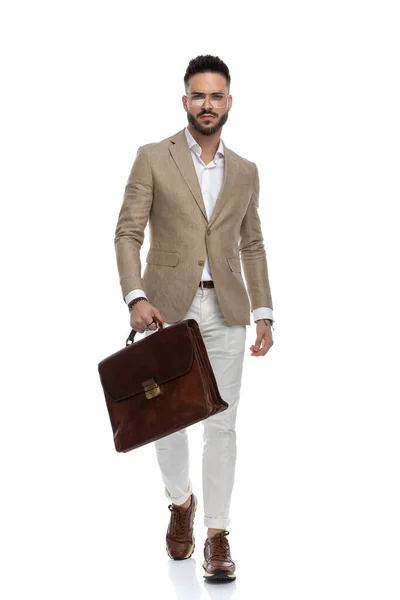 ハンサムなビジネスマンは厳しい態度で歩き白を背景にブリーフケースを持ち — ストック写真