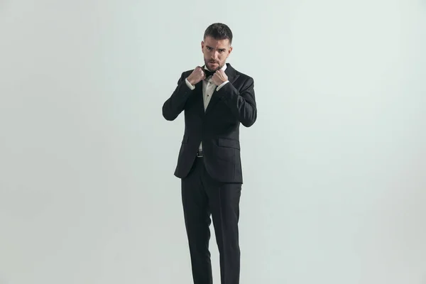 Modelo Moda Atractiva Ajustando Corbata Mirando Profundamente Cámara Contra Fondo — Foto de Stock