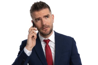 Genç yakışıklı iş adamı, telefondaki diğer kişinin ne hakkında konuştuğunu düşünüyor.