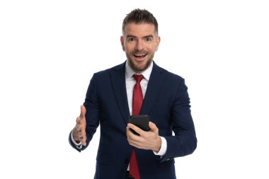 Yakışıklı iş adamı, beyaz arka planda aldığı haberle heyecanlanıyor.