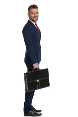 Kameraya gülümseyen ve davasını beyaz arka planda tutan mutlu bir iş adamının yan görüntüsü