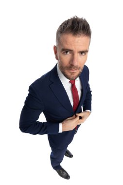 Yakışıklı bir iş adamının ciddi olduğu geniş açılı bir bakış açısı ve beyaz arka plana karşı davasını düzenleme