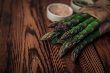 Taze serçe çimenlerinin yakın plan resmi ahşap doğrama tahtasının üzerinde tuz ve biberle pişirilmeye hazır.