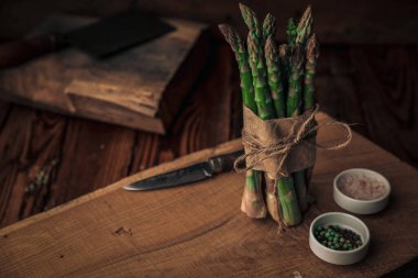 Vitaminler tuz, biber ve ahşap doğrama tahtasının tepesinde bir iple bağlanmış kuşkonmazdan toplanır.