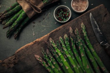 Taze kuşkonmaz, tuz ve biber ile birlikte bıçağın yanında sağlıklı bir yemek hazırlıyorum.