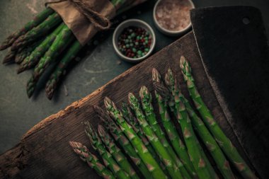 Taze sebzeler, arka planda tuz reklamı biberlikleri olan balta tarafından doğranmaya hazır.