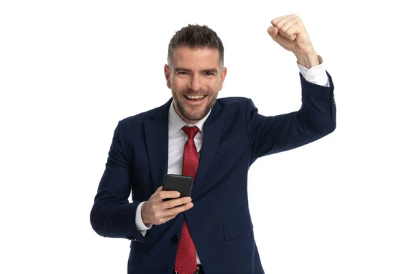 Empresário Atraente Comemorando Sucesso Segurando Telefone Contra Fundo Branco — Fotografia de Stock
