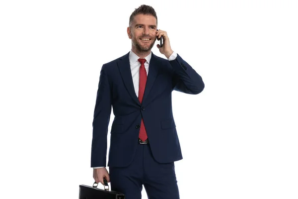 Bonito Empresário Ouvindo Telefone Segurando Caso Sorrindo — Fotografia de Stock