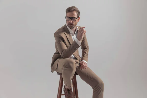 Κάθεται Επιχειρηματίας Φορώντας Ένα Ωραίο Κοστούμι Ακουμπά Χέρια Του Στην — Φωτογραφία Αρχείου