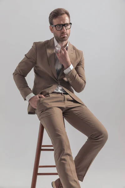 时尚图片 性感的商人像老板一样 把衣领系好 坐在椅子上 摆出一副坚定的姿势 — 图库照片