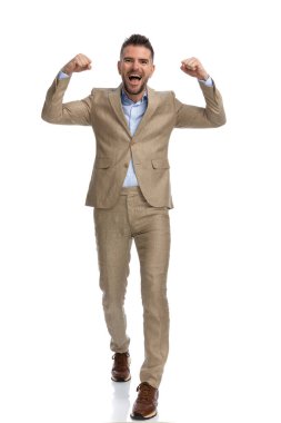 Kolları havada gezen, bağıran ve beyaz arka planda kazananı kutlayan şampiyon iş adamı.