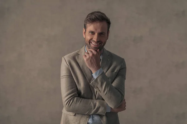 Atrakcyjny Biznesmen Składający Ramiona Dotykający Podbródka Uśmiechający Się Kamery Tapetę — Zdjęcie stockowe