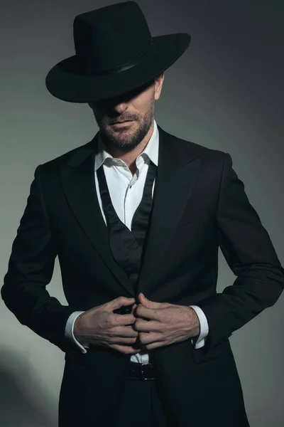 Portrait Attractive Man Undone Tie Wearing Black Hat Adjusting Tuxedo — стоковое фото