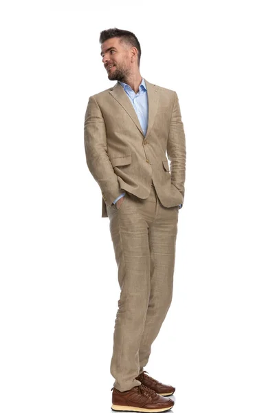 Curious Guy Beige Suit Hands Pockets Looking Shoulder Front White — Stok fotoğraf