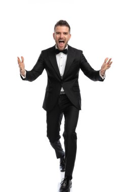 Çekici iş adamı yüksek sesle bağırıyor ve beyaz arka plana karşı coşkuyla başarıyı kutluyor.