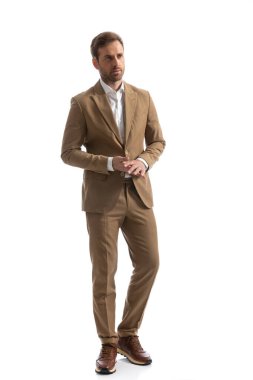 Çekici iş adamı avuçlarını ovuyor, başka tarafa bakıyor ve beyaz arka planda yürüyor.