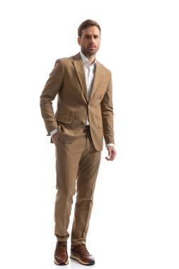 Yakışıklı iş adamı bir elini cebine soktu ve beyaz stüdyo geçmişine karşı poz verdi.