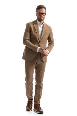 Yakışıklı iş adamı kameraya doğru yürürken avuçlarını ovalıyor.