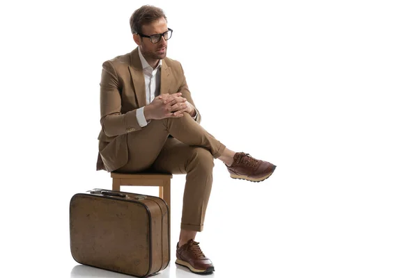 Homem Negócios Atraente Segurando Joelho Enquanto Olha Para Lado Sentado — Fotografia de Stock