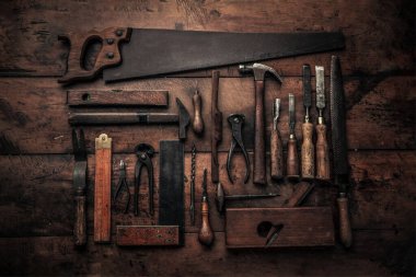 flat lay picture of big set of vintage tools used for carpentry with  crowbar, handsaw, planer, screwdrivers, spirit level on top of workbench for grandious art