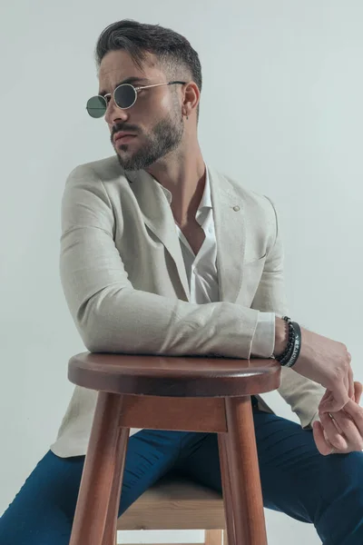 Sexy Man Glasses Untied Shirt Holding Arm Wooden Chair Looking — стоковое фото