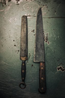 vintage collection of old rusty kitchen knife and knife sharpener on top of metallic texture 