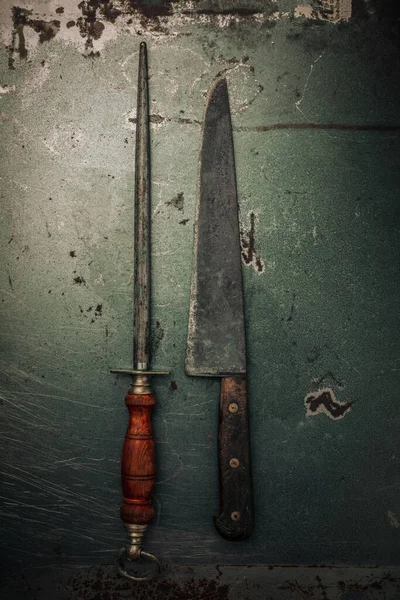 decayed metallic texture with set of old knife sharpener and kitchen knife on top, flat lay