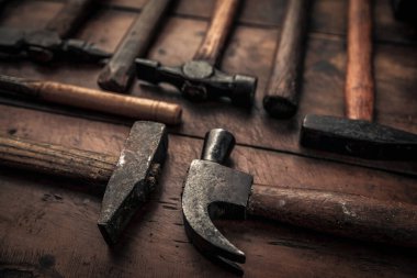 old rusty mallets equipment for carpentry, shoemaking, body work and geological industry in top of rustic old workbenc
