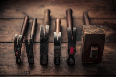 set of old vintage rusty carpentry equipment on top of rustic wooden workbench illustrating the concept of craftsmanship and manual work